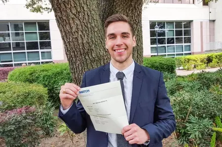 Andres headshot with Match paperwork