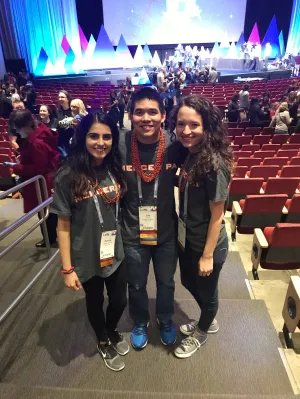 three students in auditorium